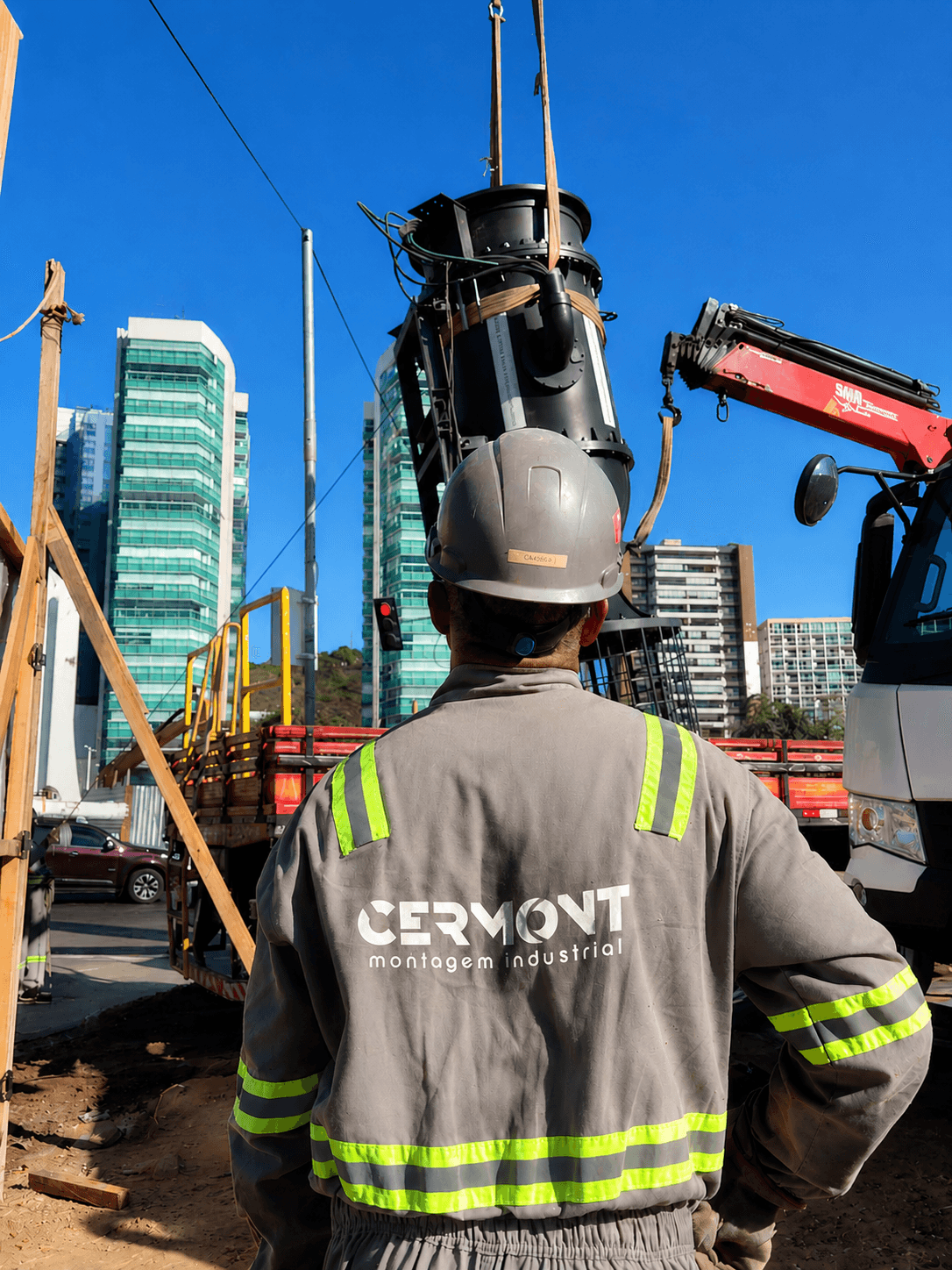 Funcionário acompanha içamento de equipamento para instalação